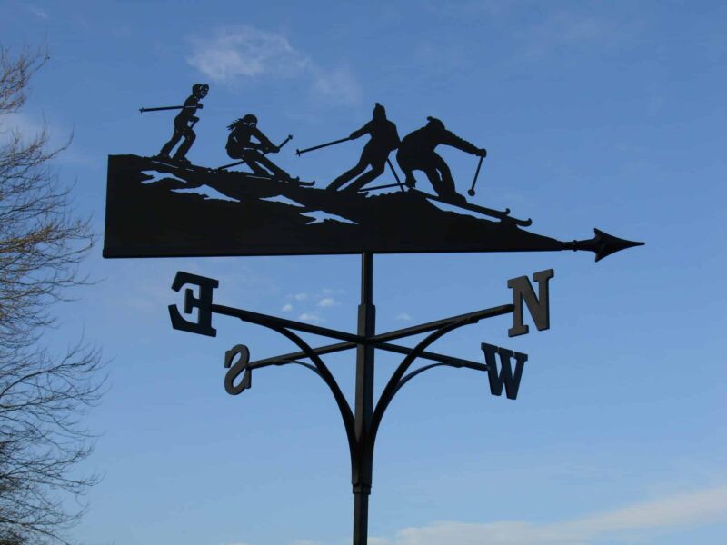 handmade black ski holiday weathervane showing 4 skiers in the alps on a black silhouette