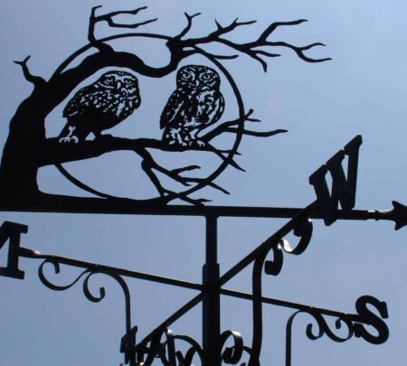 a Pair Of Owls In Tree With Moon. this is a black Weathervane design against a blue sky