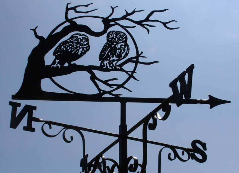 a Pair Of Owls In Tree With Moon. this is a black Weathervane design against a blue sky