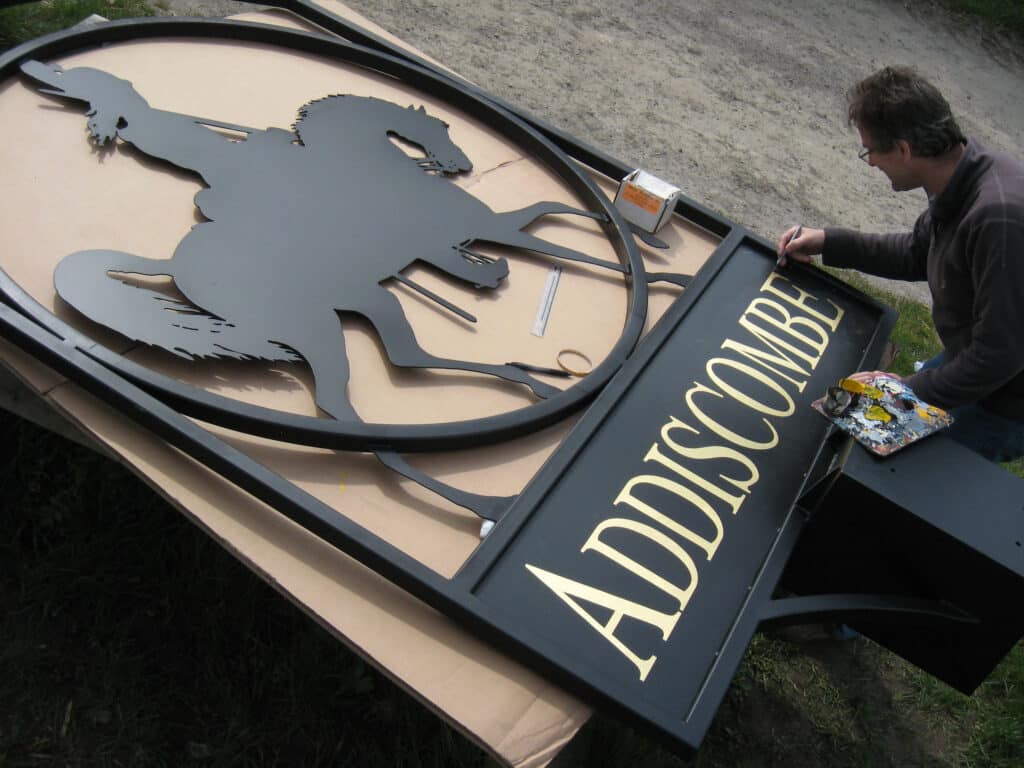 Nick taking the opportunity of the weather to sign write the Addiscombe town sign outdoors